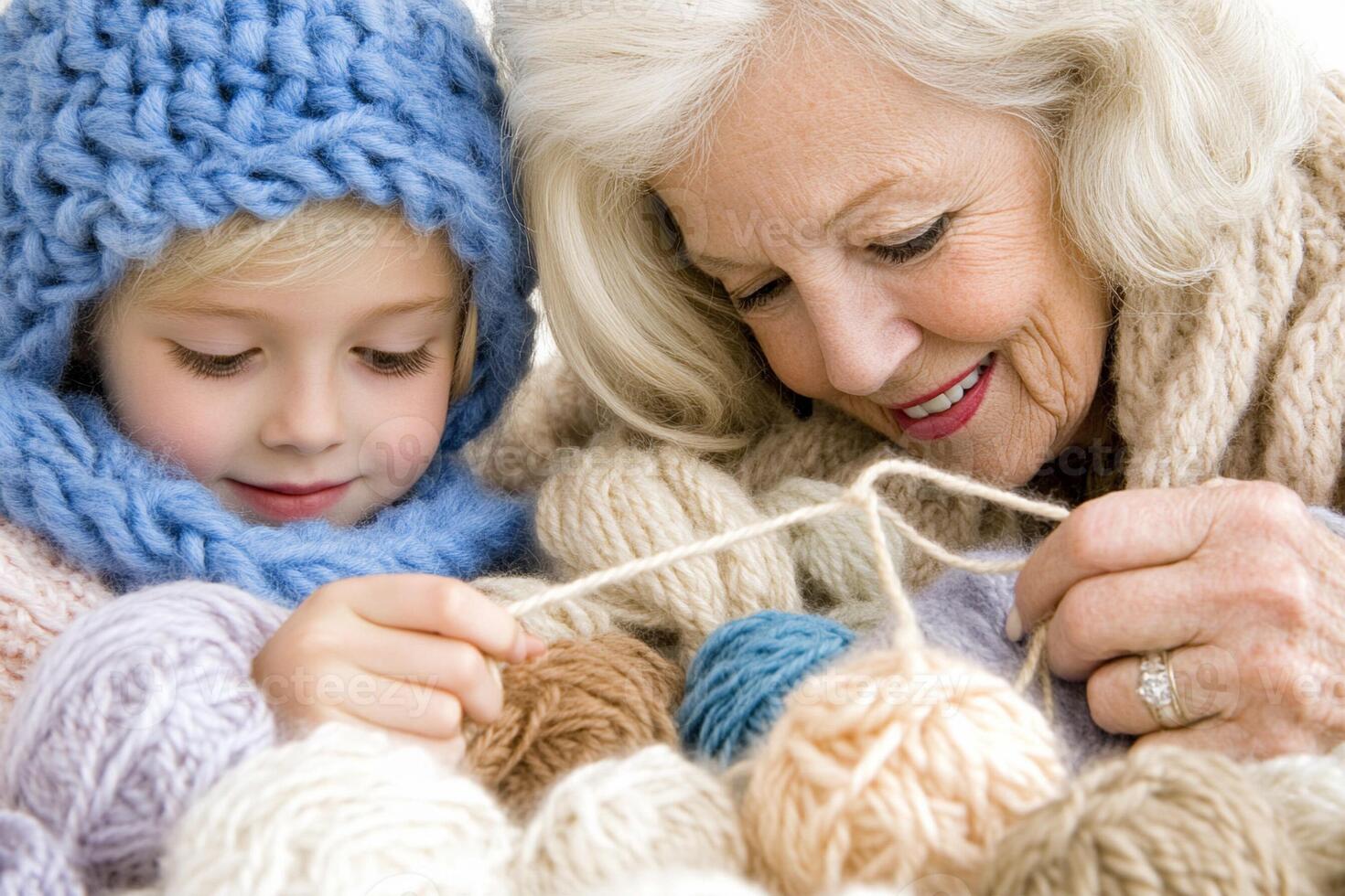 An older woman and a young girl are knitting together photo