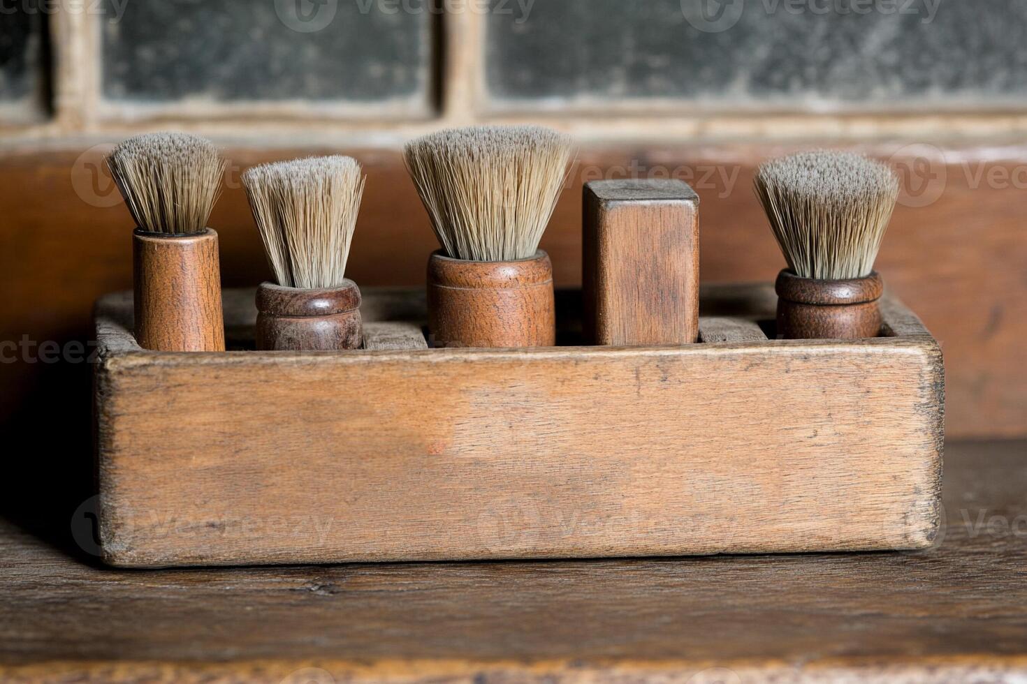 A wooden box with five brushes in it photo
