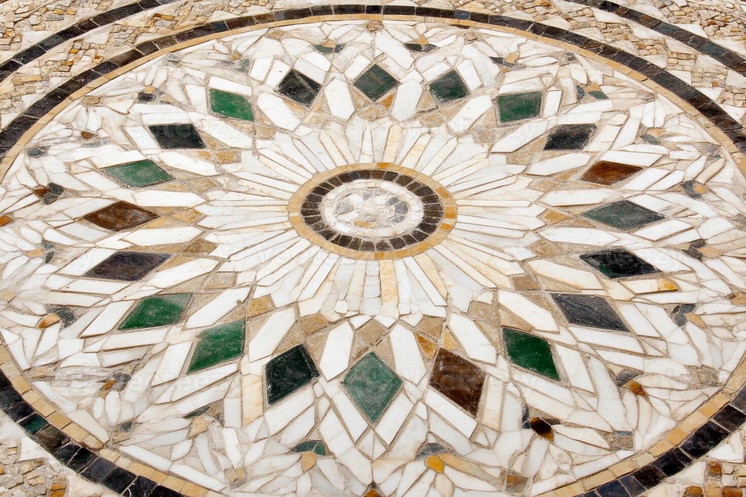 A circular mosaic tile with a flower design photo