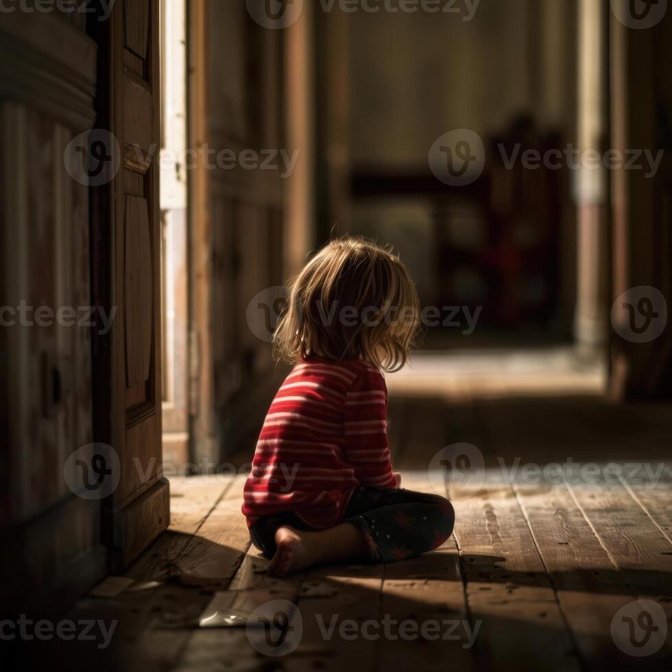A little girl sitting on the floor in an empty room photo