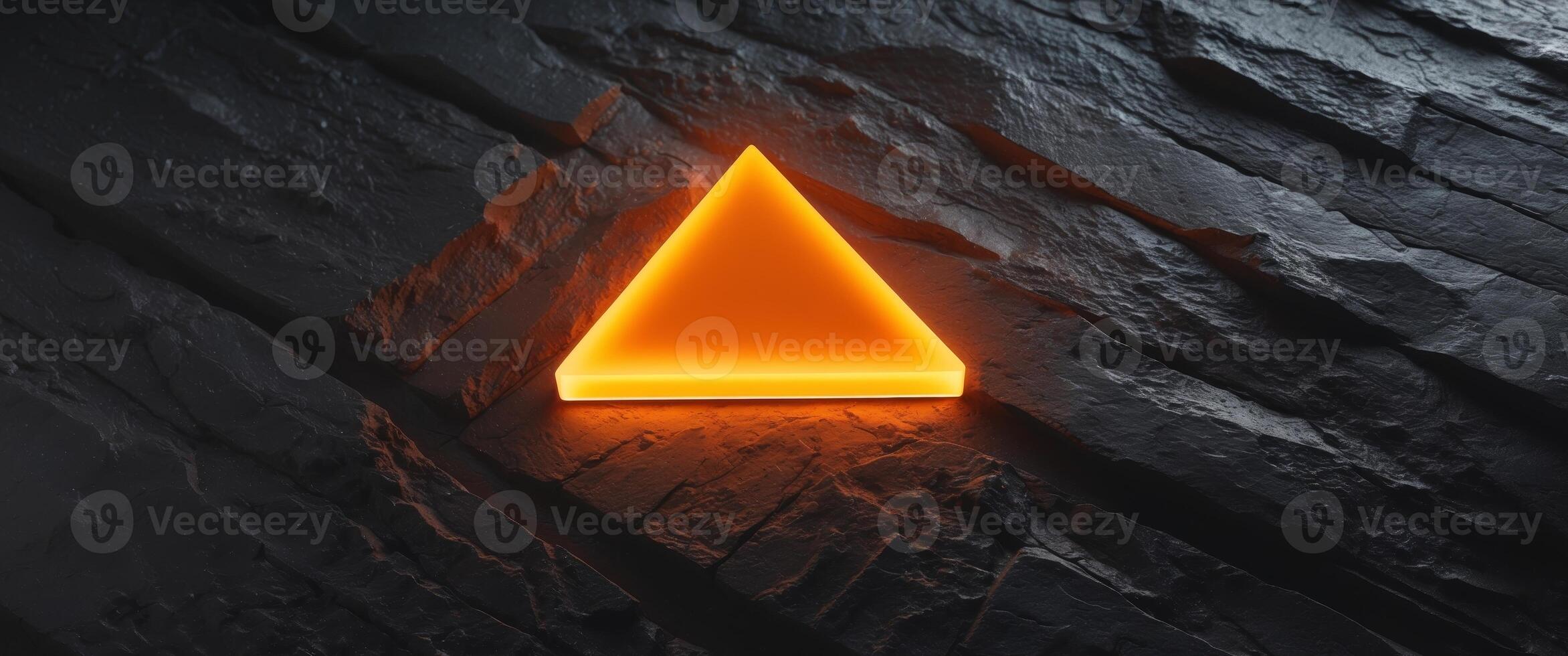 A Glowing Orange Triangle Illuminates A Dark Textured Surface. photo