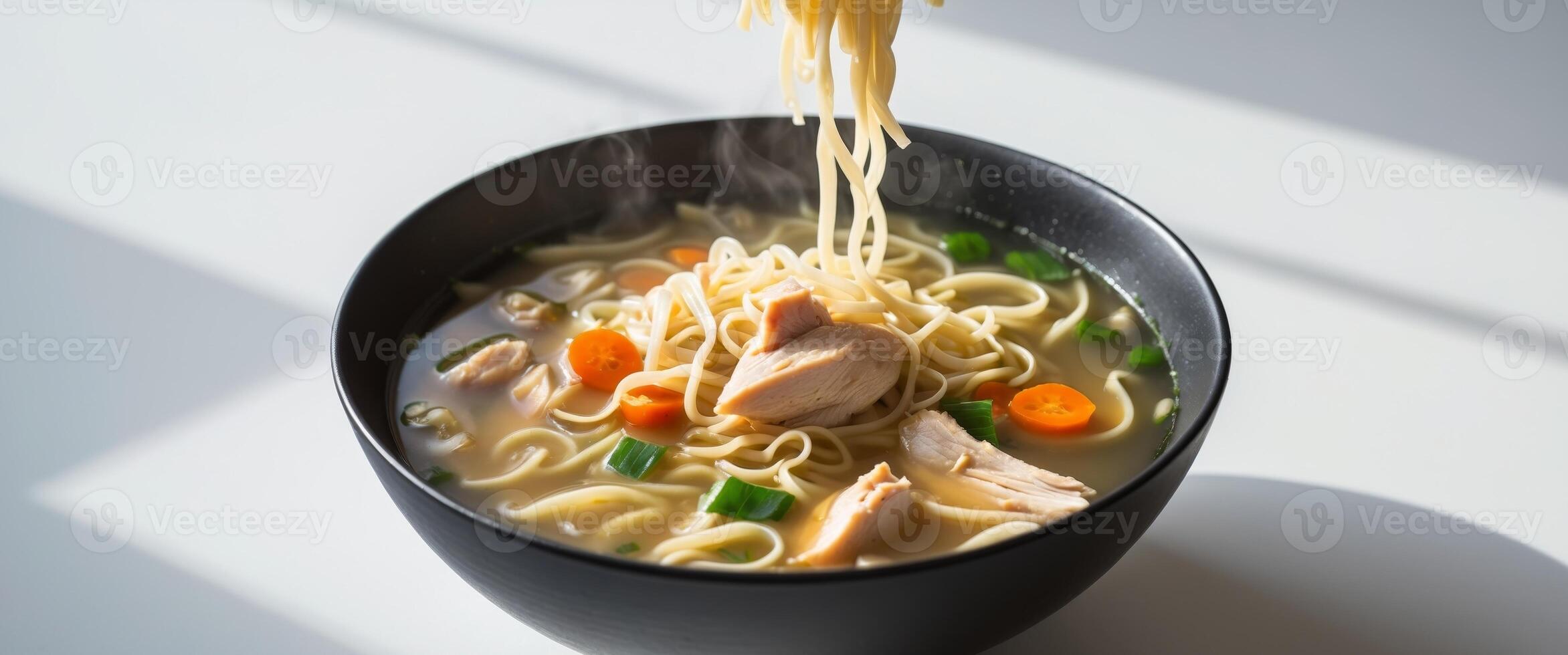 Delicious Chicken Noodle Soup in a Black Bowl. photo