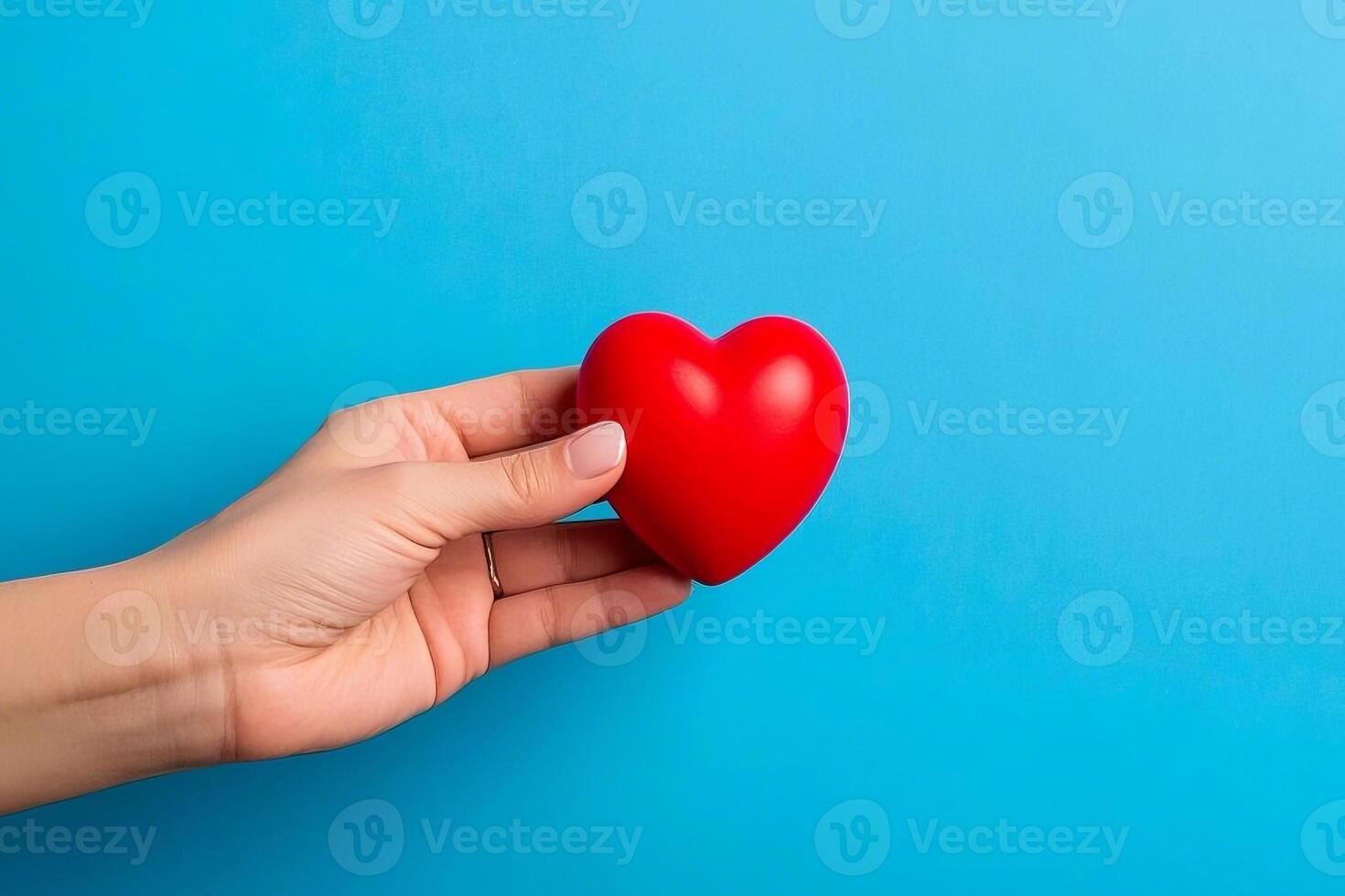 Symbol Of Love Red Heart Resting In A Hand With A Blue Background photo
