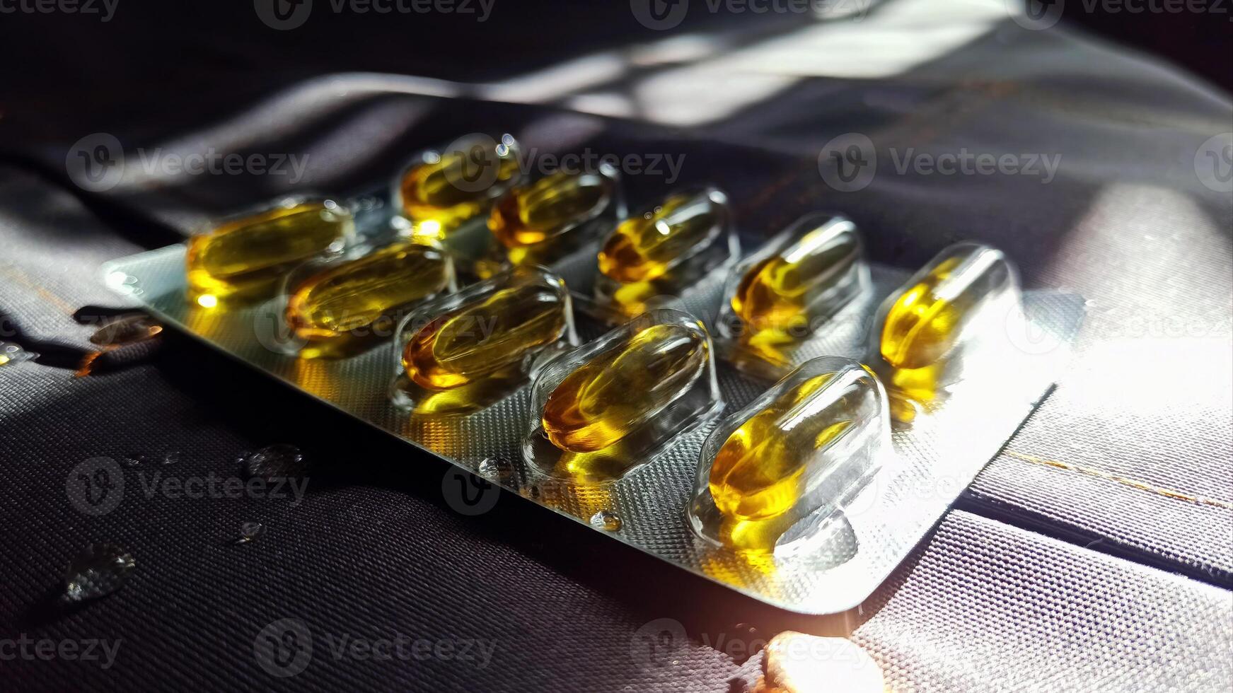 Closeup view of transparent gel capsules filled with oil, showcasing their design and texture. These dietary supplements, emphasize their relevance in promoting health. photo