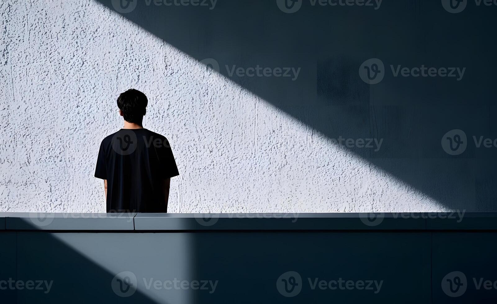 A man stands in front of a wall with a shadow photo