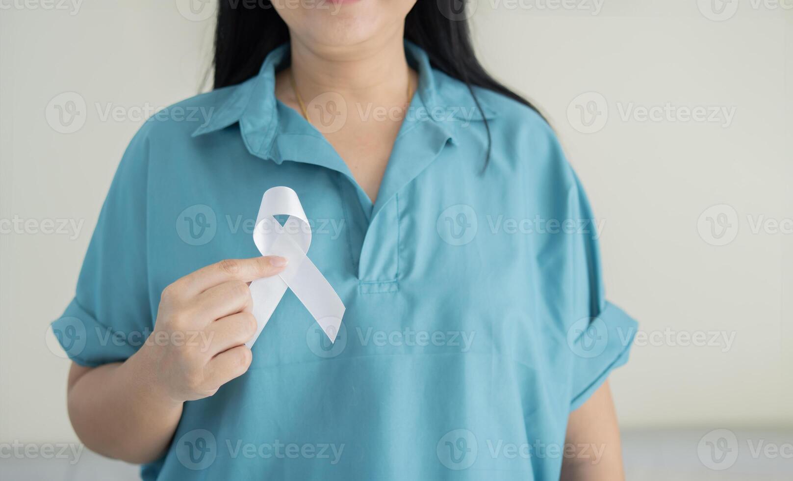 Healthcare and medicine concept. female hands holding white ribbon. Lung cancer awareness. photo