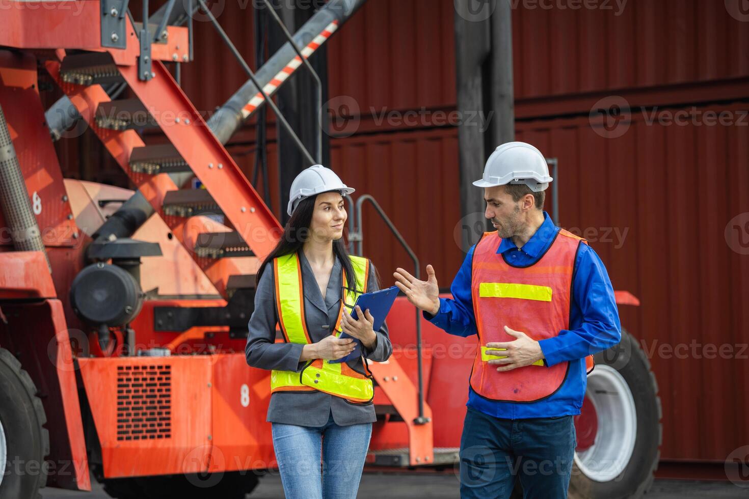 Supervisor in safety gear and engineer in hardhat checking and control loading containers box from shipping yard, Workers collaborating at shipping container cargo photo
