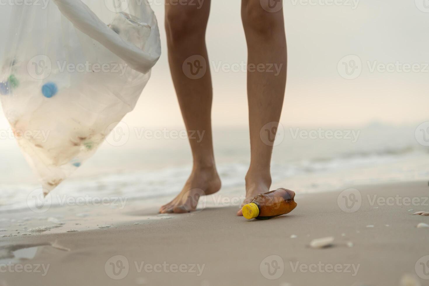 Volunteer pick up trash garbage at the beach and plastic bottles are difficult decompose prevent harm aquatic life. Earth, Environment, Greening planet, reduce global warming Save world. photo