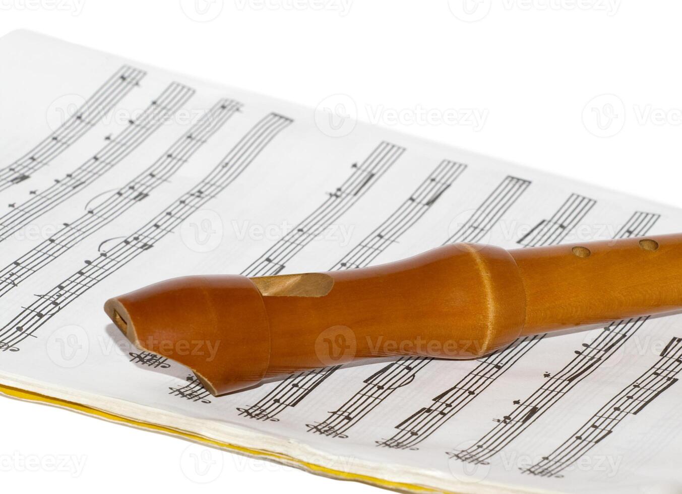 Recorder on a sheet music over white photo