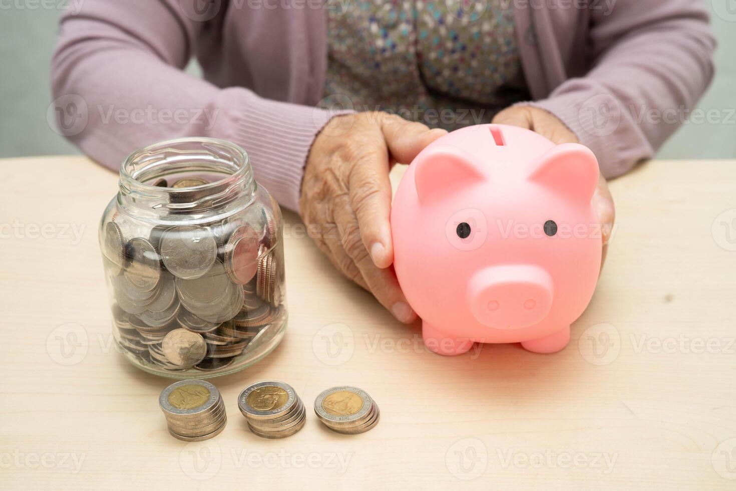 Retired elderly woman counting coins money with piggy bank and worry about monthly expenses and treatme photo