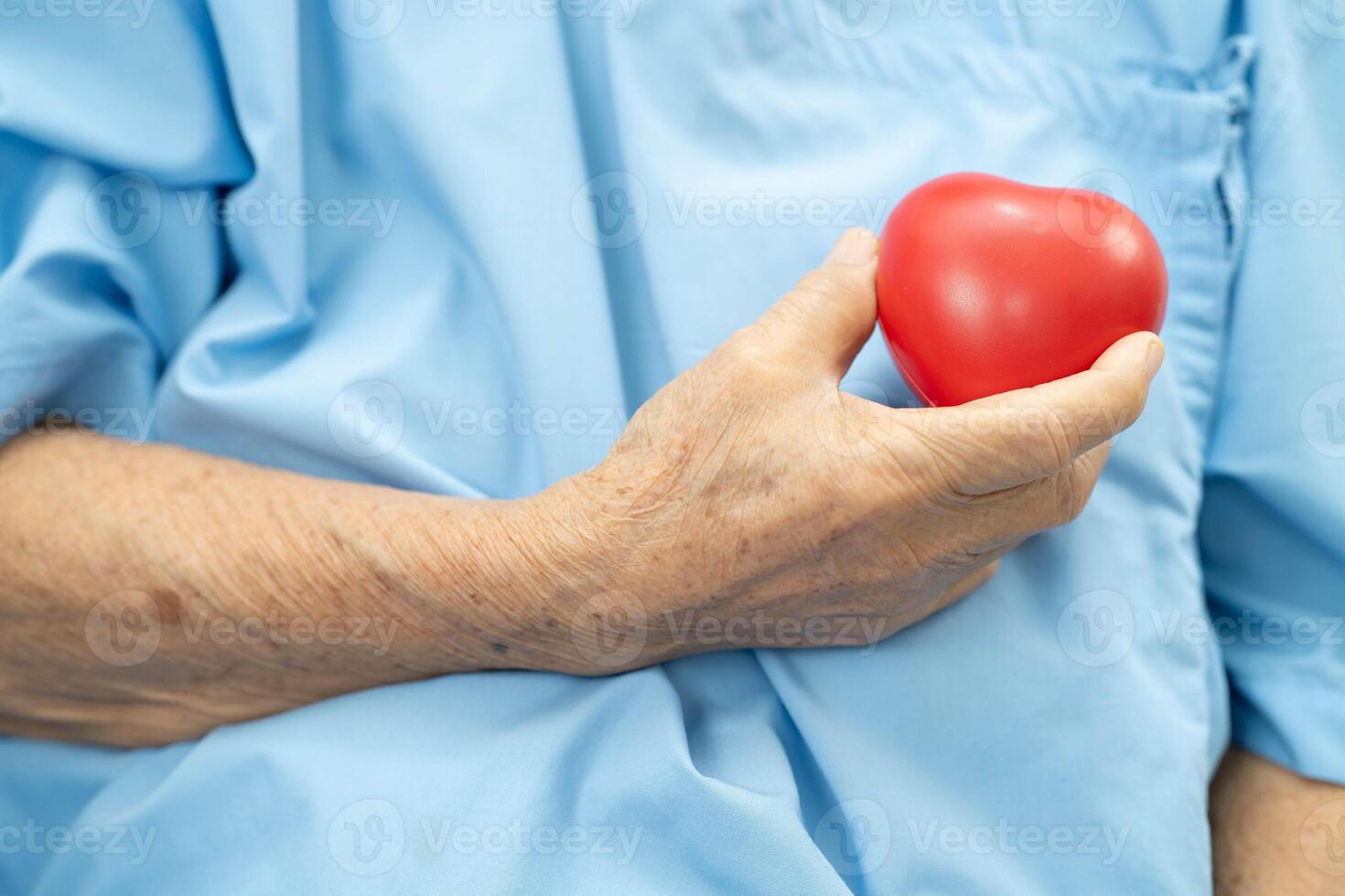Asian elder senior woman patient holding red heart in ho photo
