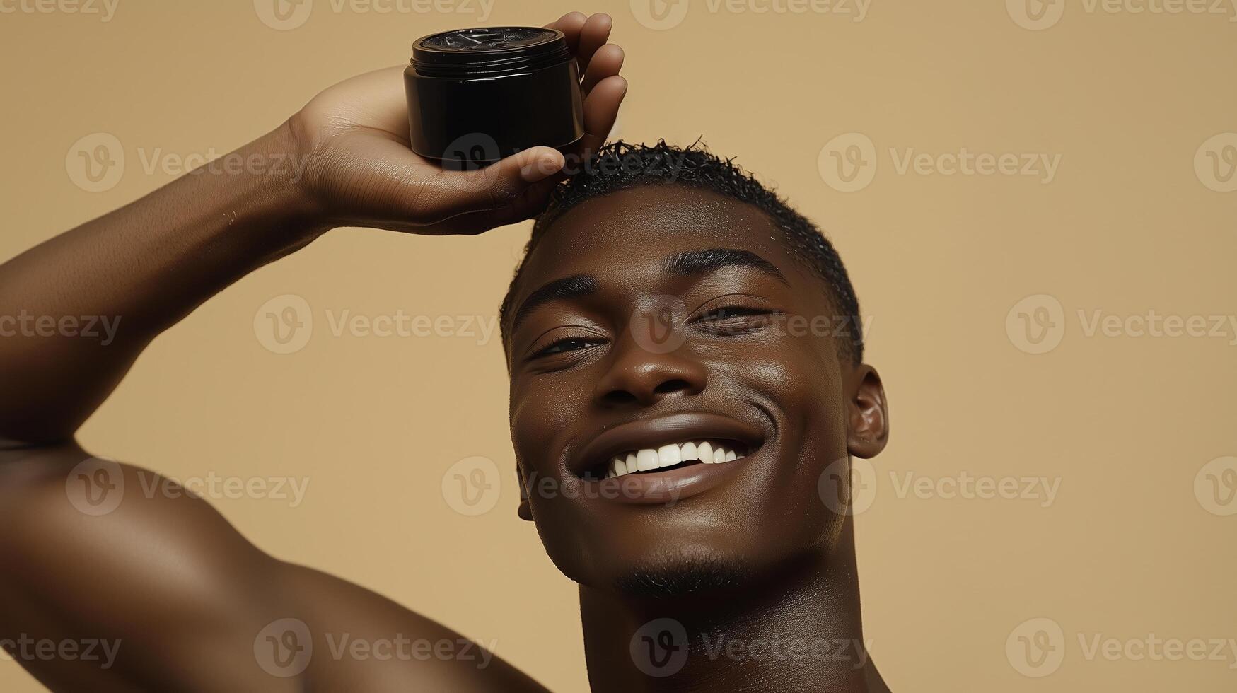 Male model with smiling expression holding black body balm in hand above head. 5 photo