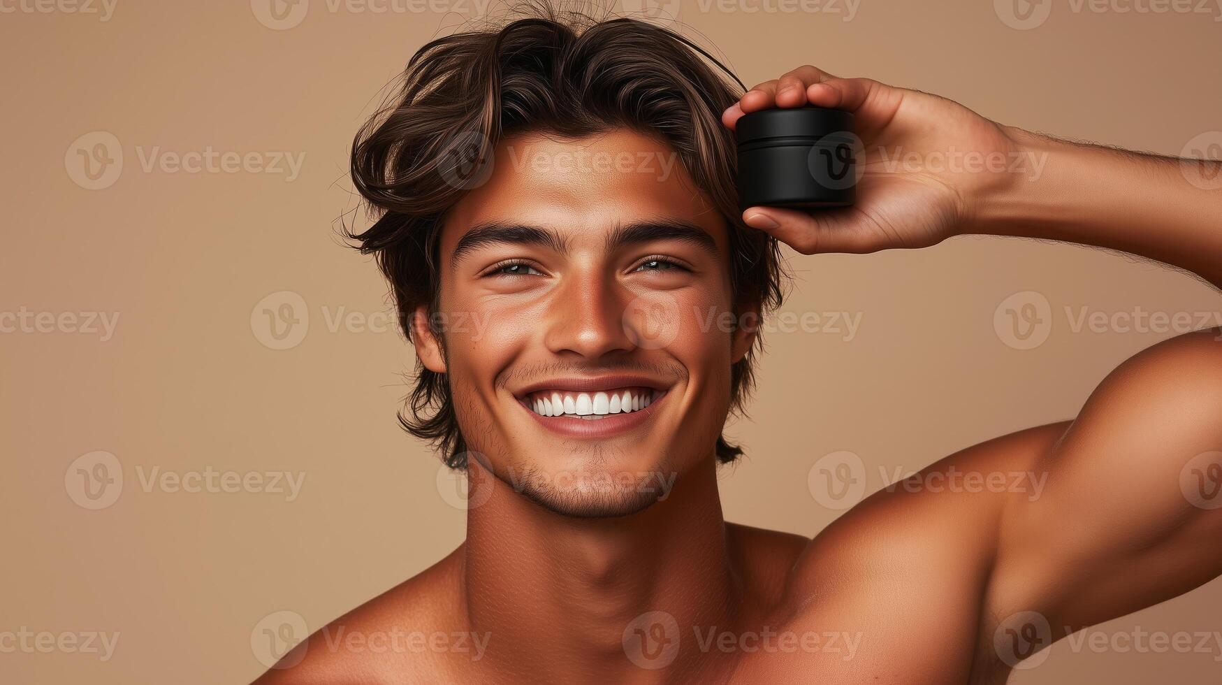 Male model with smiling expression holding black body balm in hand above head. 6 photo