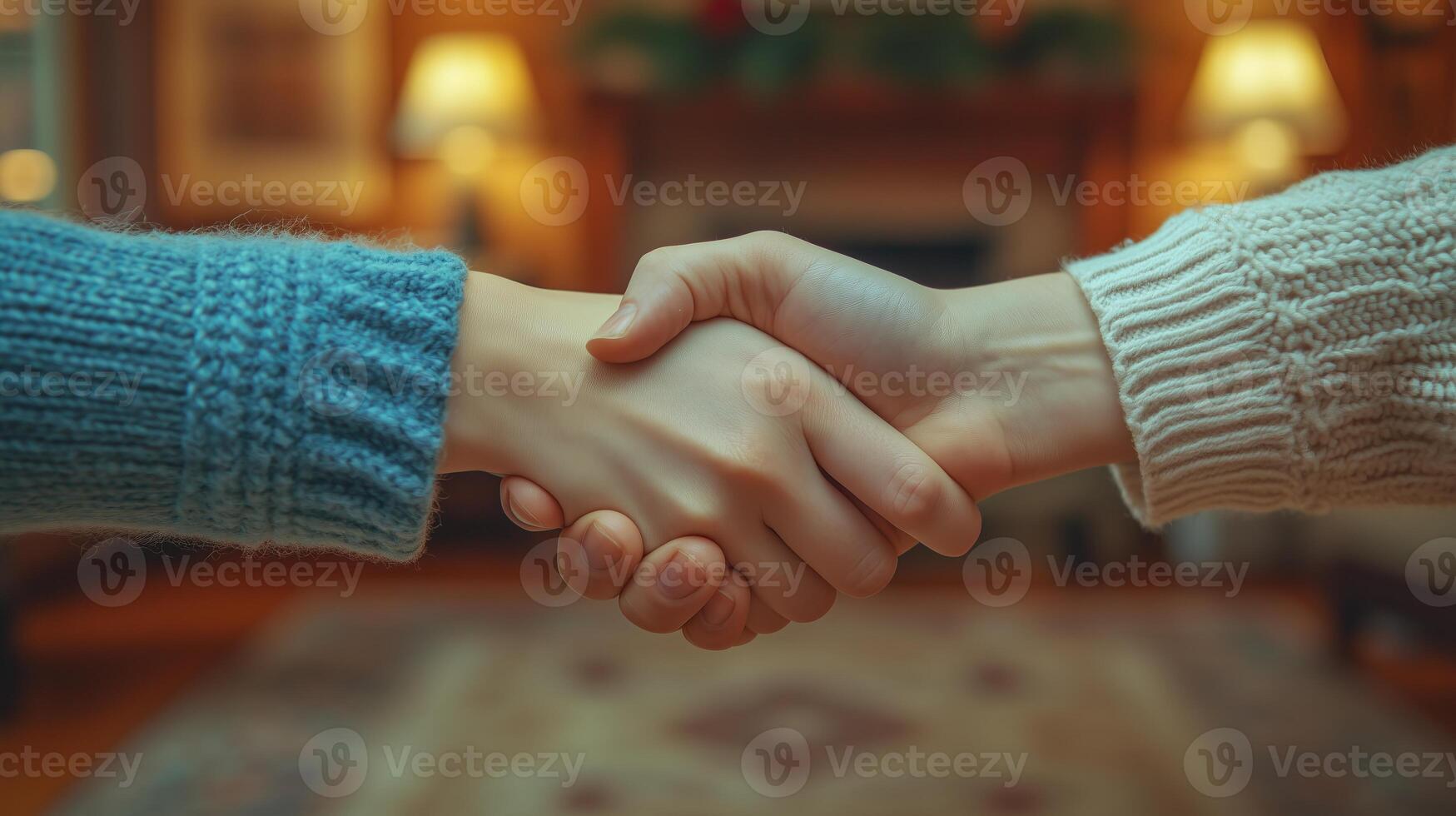 Close-up of two people shaking hands, with a living room background. 4 photo