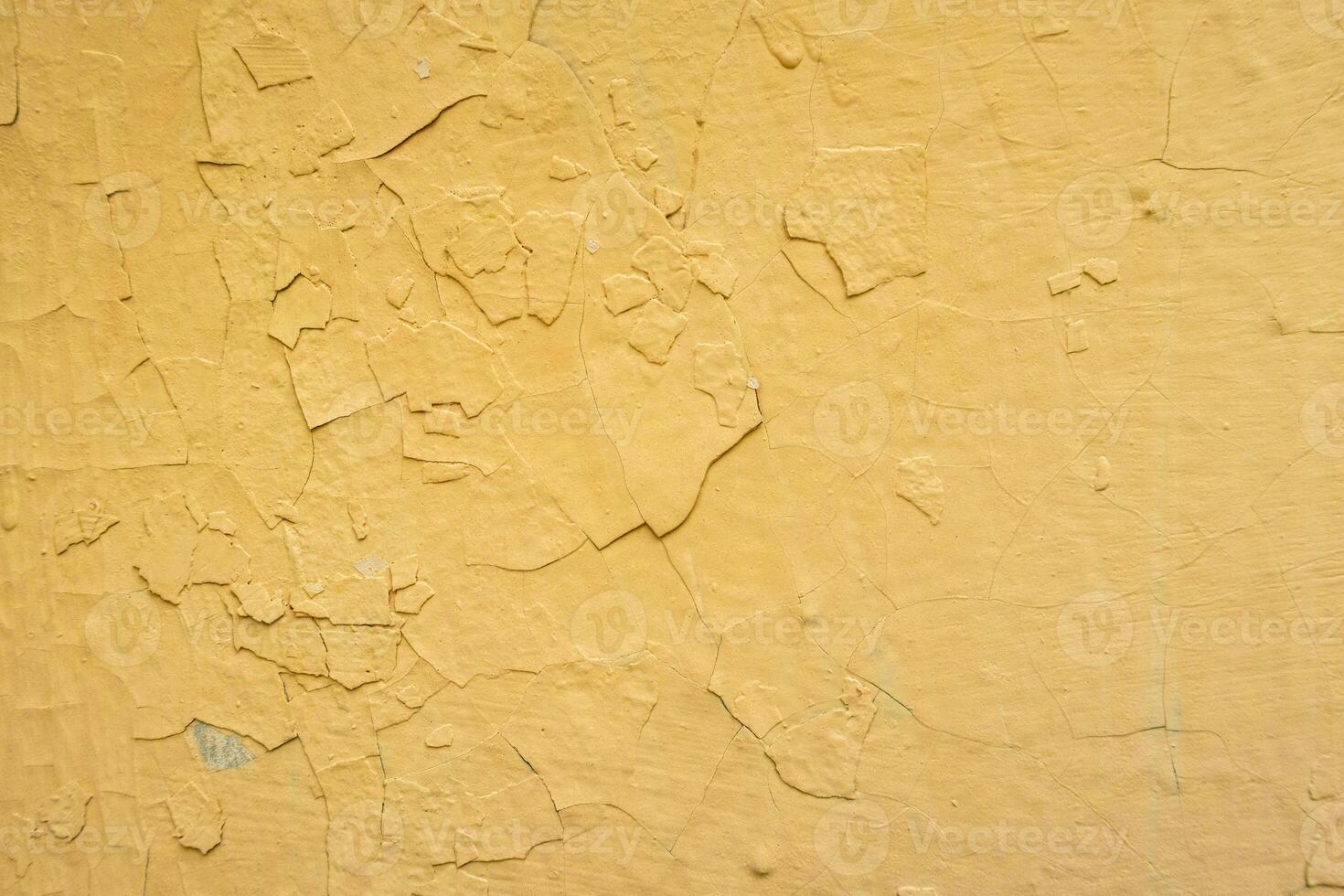 Background yellow wall colored with many layers of paint which is peeling photo
