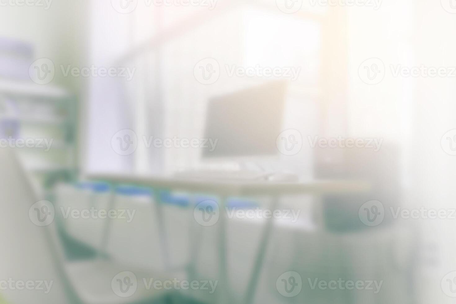 Blur office background with working desk and computer. Light is coming through the window. photo