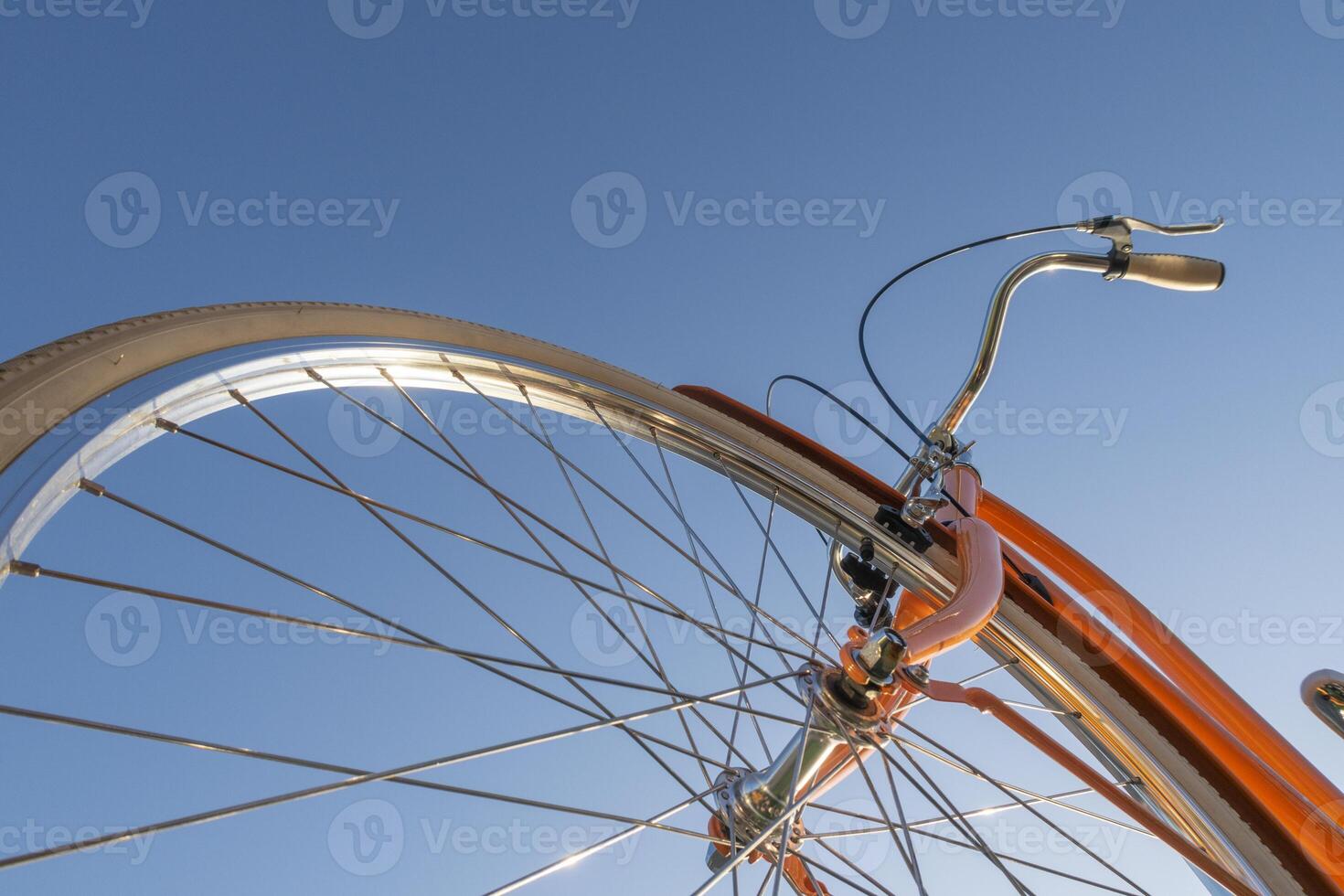 Part of bicycle with handlebar and wheel against blue sky. photo