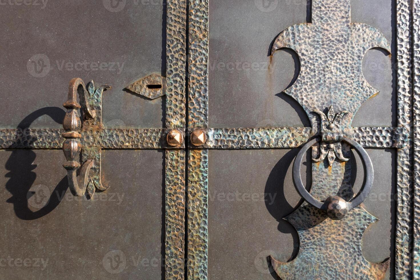 Handle, knocker and lock of an old metal door. photo