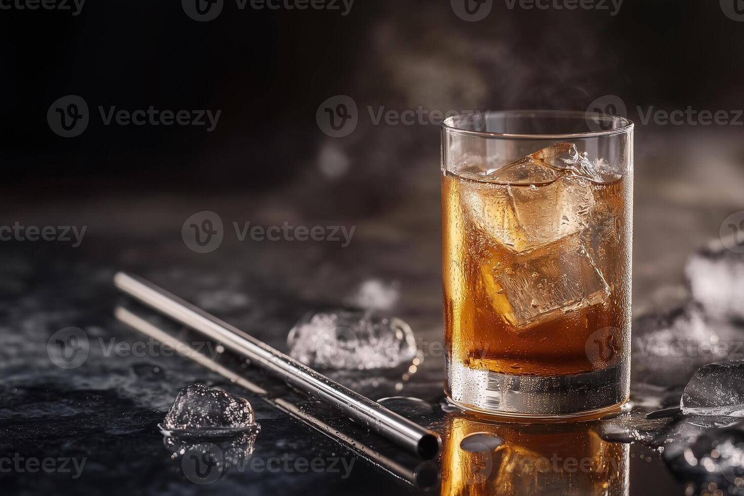 Stylish metal straw rests beside a glass filled with ice and amber beverage on a dark table at a trendy location photo
