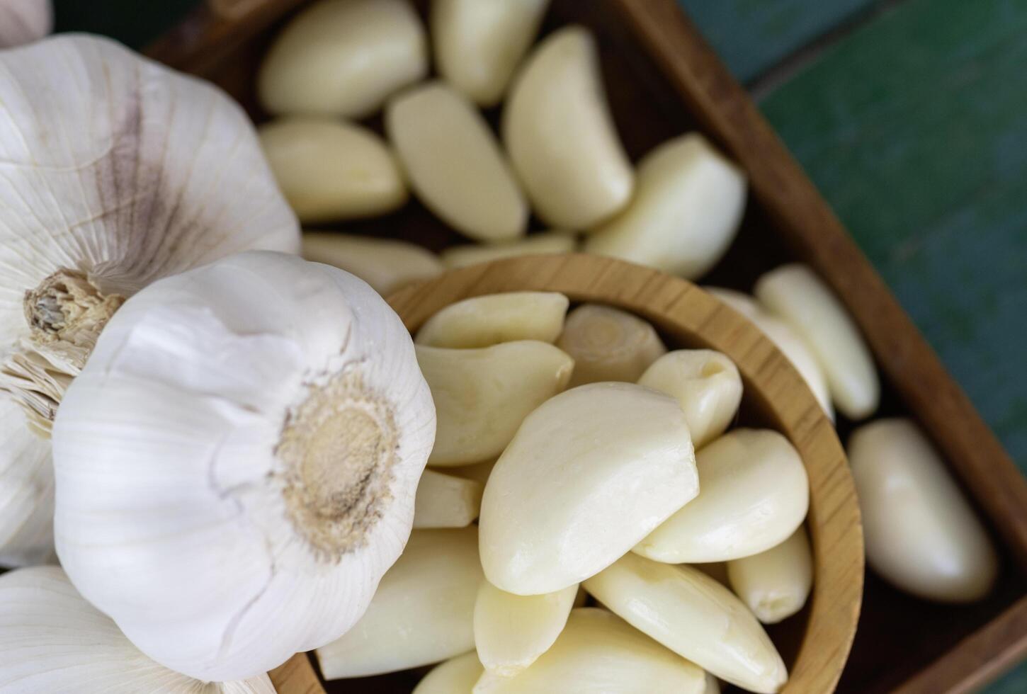 Peeled garlic in wooden bowl photo
