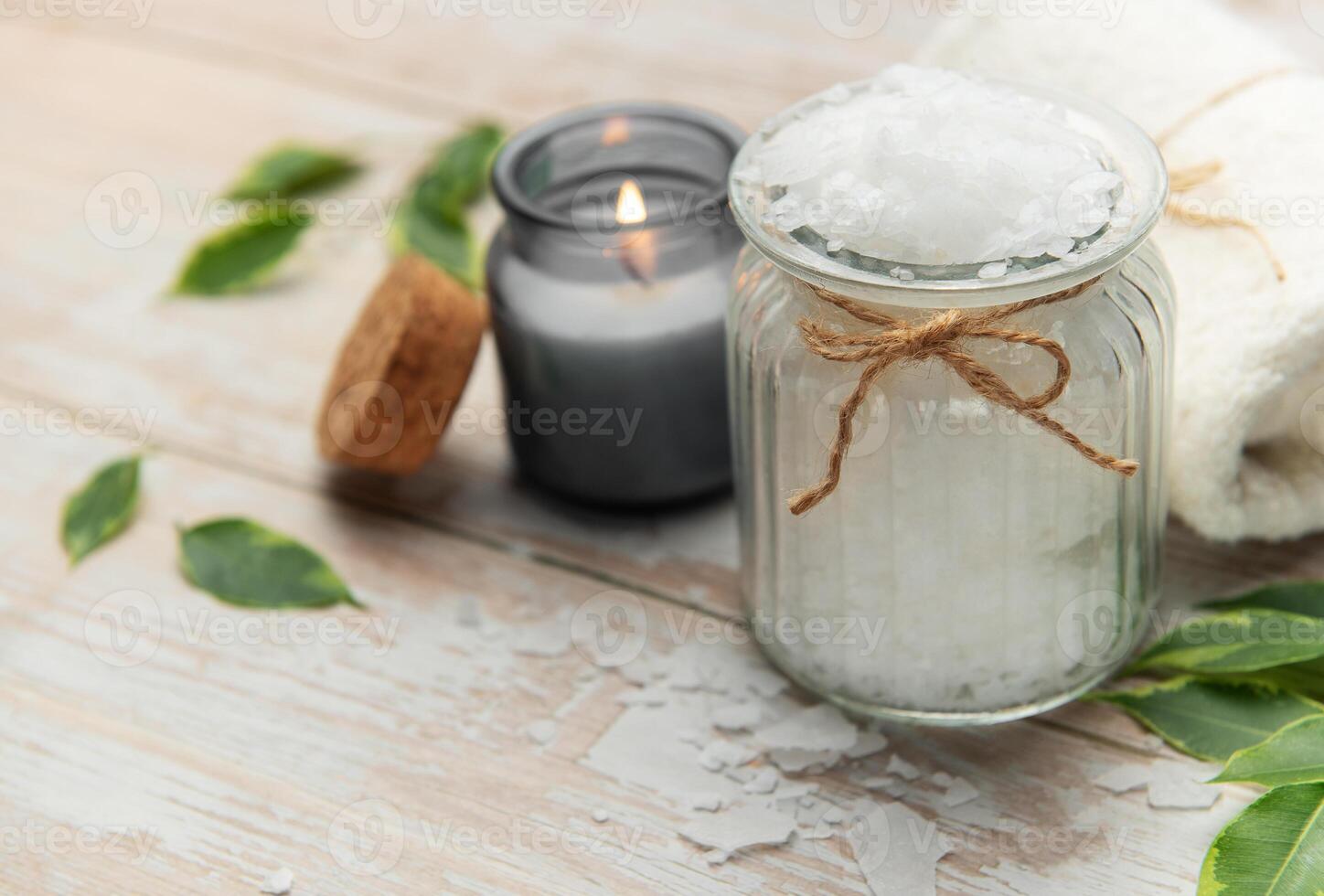 Magnesium flakes in a jar with burning candle for a relaxing spa treatment photo