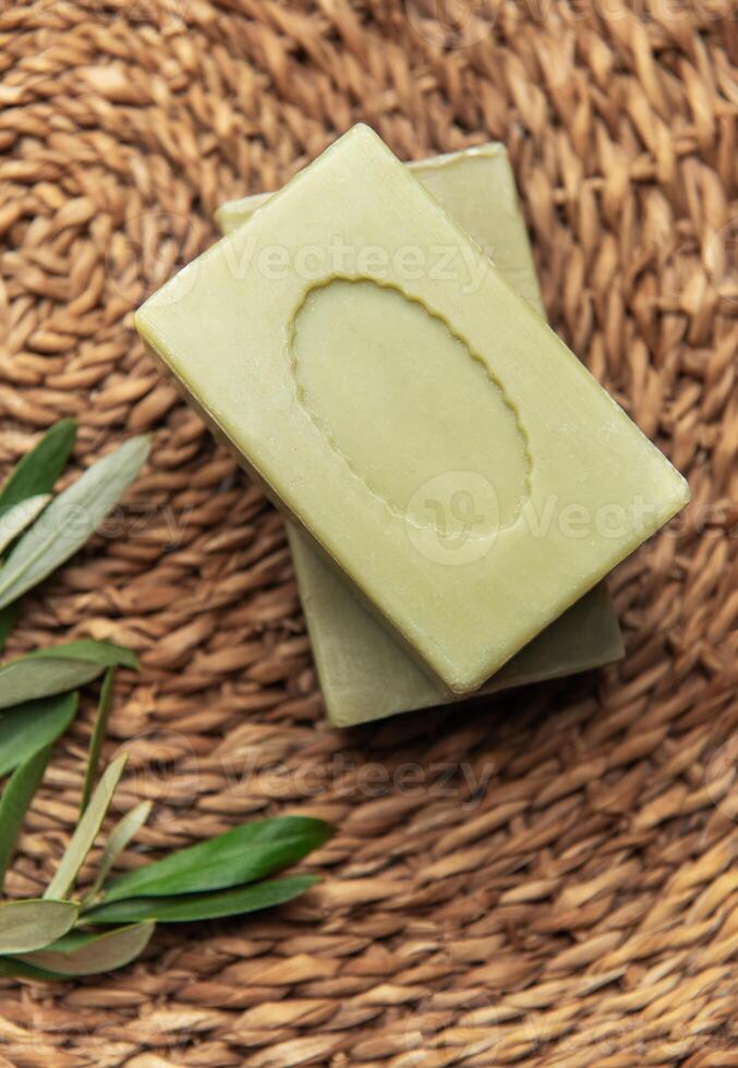 Olive soap bars on a woven mat with olive branch photo