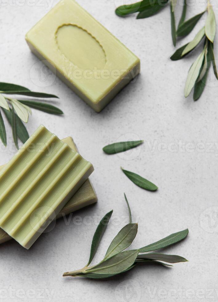 Olive soap bars and olive branches resting on marble photo