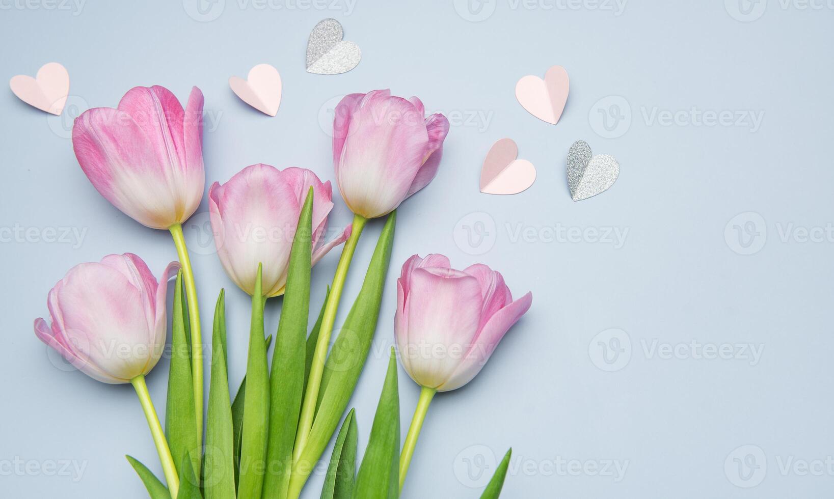 Pink tulips and paper hearts creating a romantic atmosphere photo