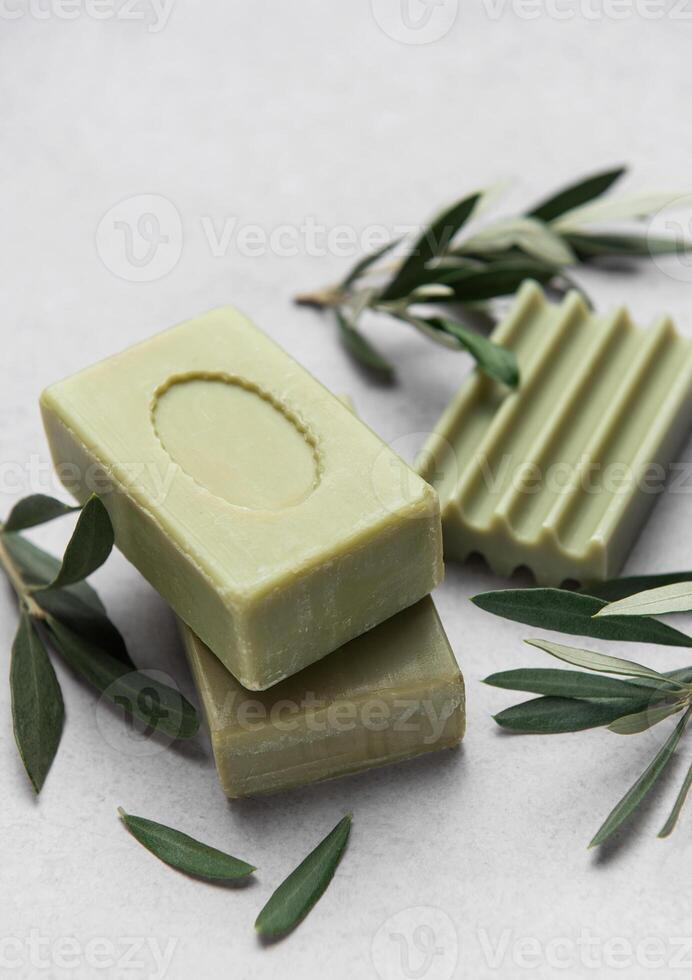 Olive soap bars on marble surface with olive branches photo