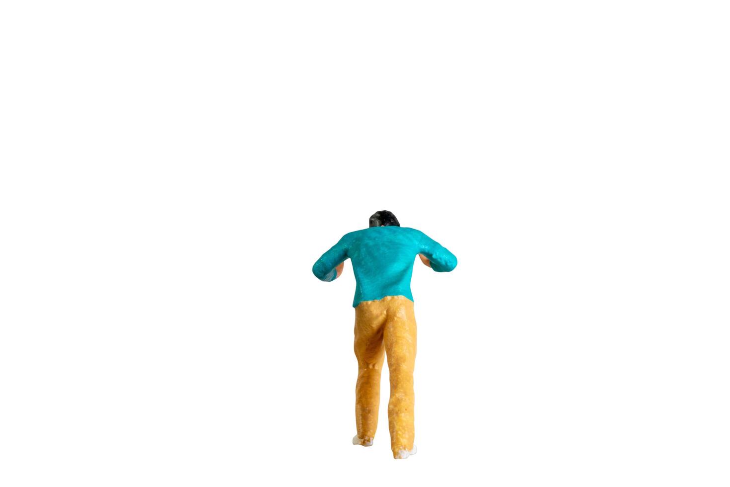 Miniature Figurine Pushing Against Invisible Force isolated on white with clipping path photo