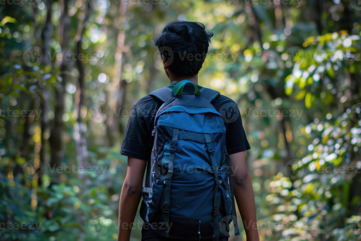 A man with a backpack walking through the woods photo