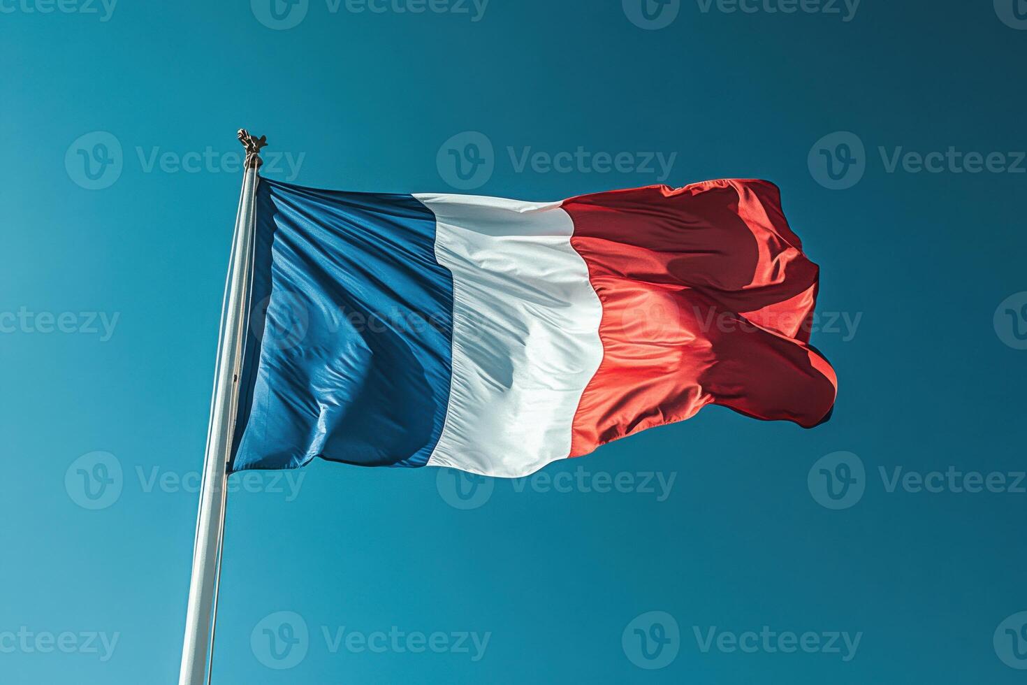 Elegant Display of the French Flag Waving Gracefully Against a Clear Sky for Celebratory Contexts photo