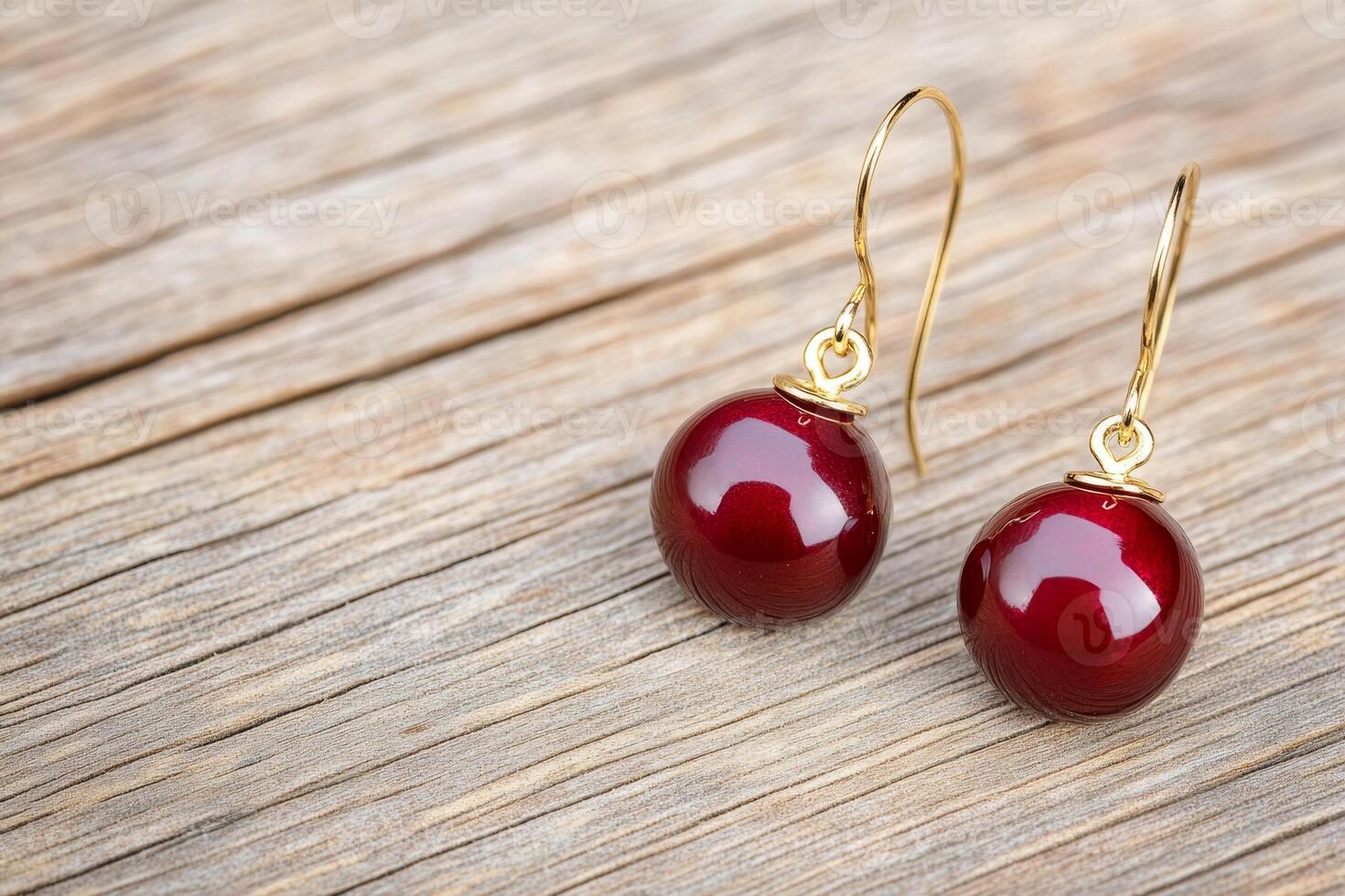 Vintage dark cherry earrings with gold accents on a wooden table evoke chic nostalgia photo