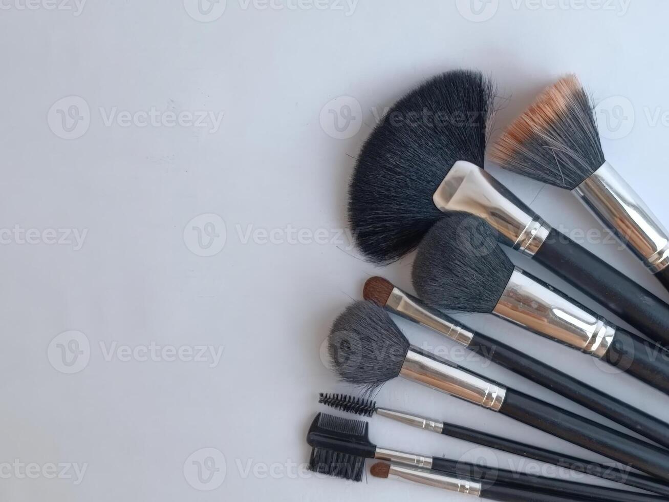 A set of makeup brushes arranged in a row, showcasing various styles useful for cosmetic applications and beauty routines. photo