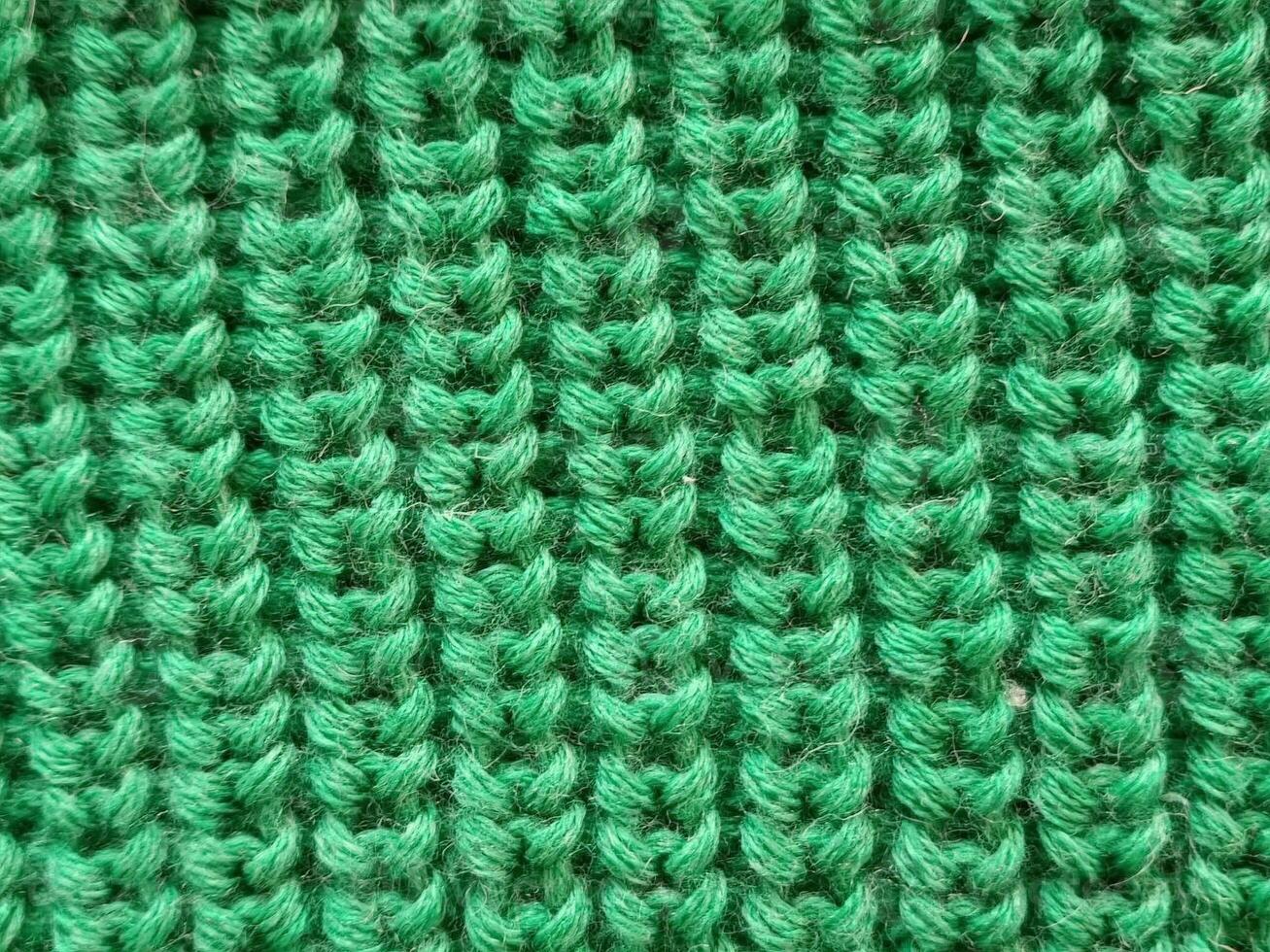 Close-up of textured green fabric, showcasing a fine knit pattern. Ideal for textile and fashion-related content. photo