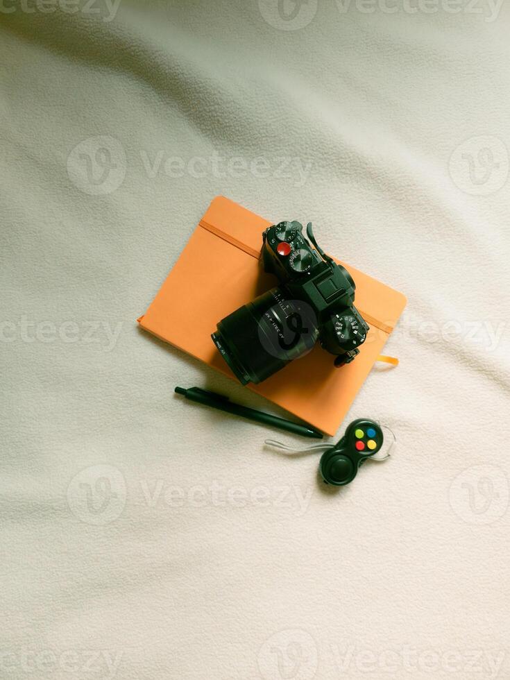 Analog camera on an orange notebook. Still life photo for a header or website banner. Internet blog concept.