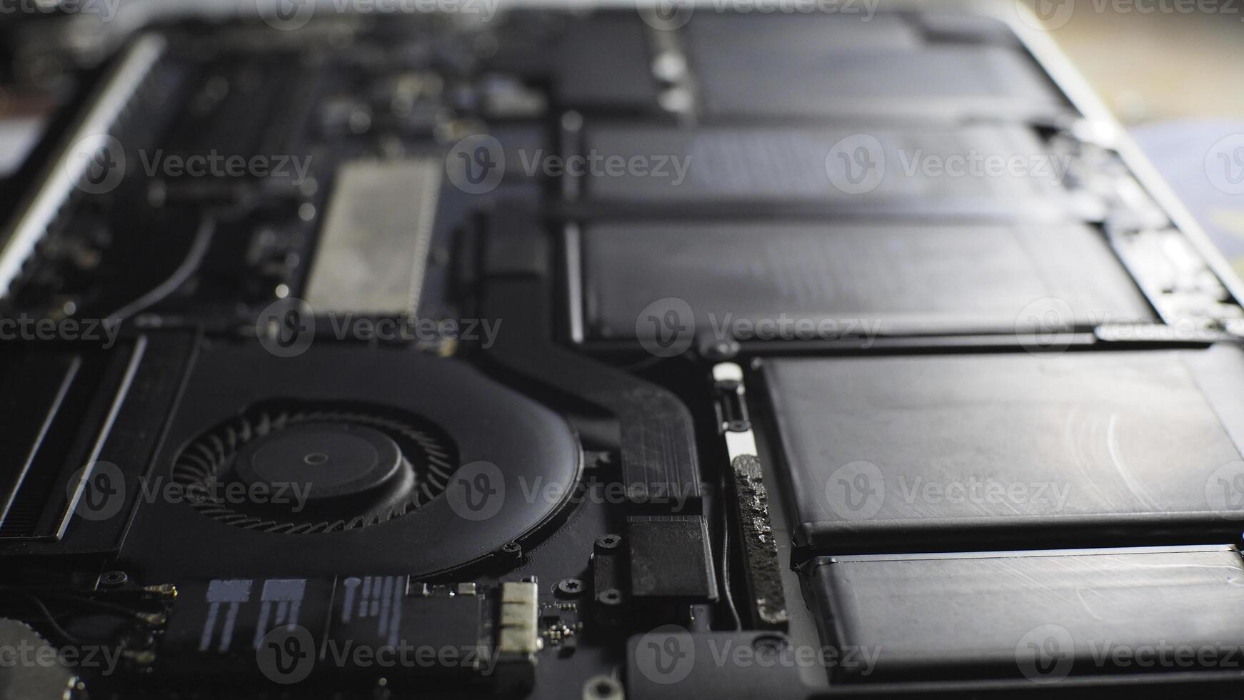a close up of a MacBook motherboard with a fan photo