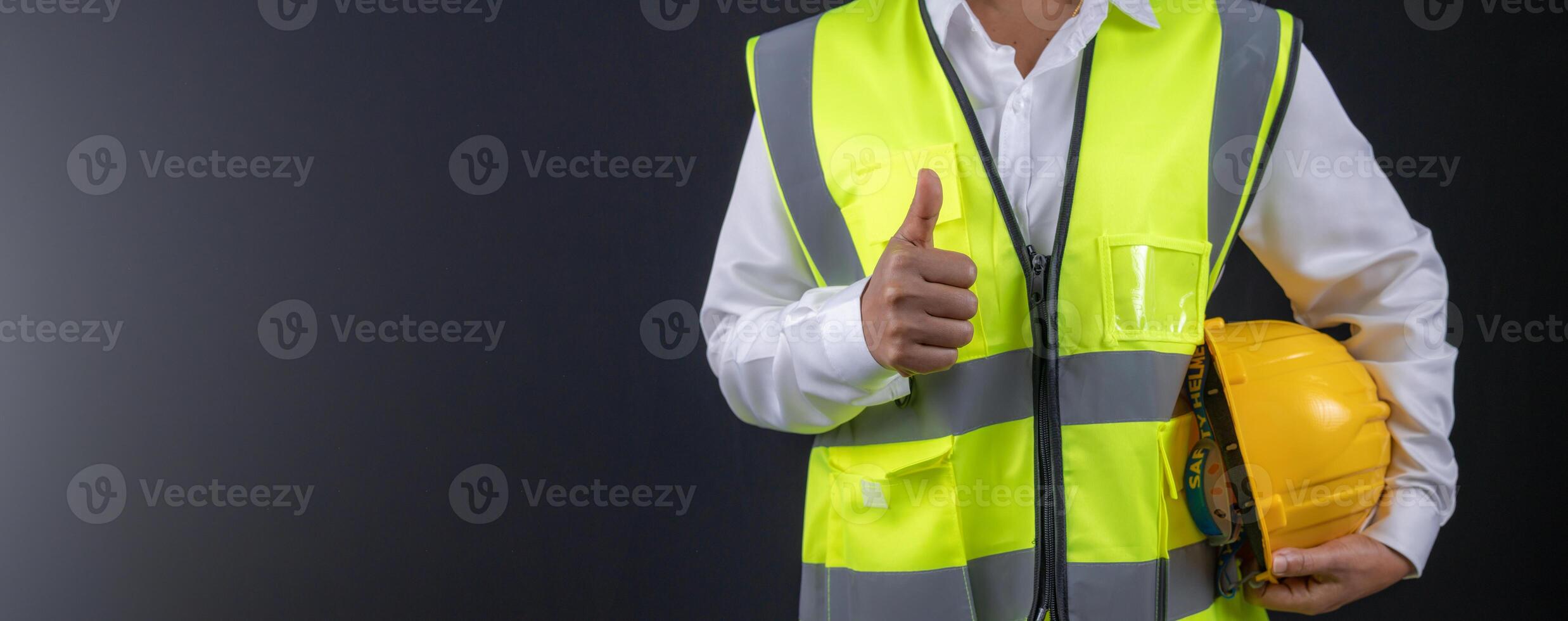 Civil engineer architect standing holding a safety helmet on dark background, Construction site plans to build high-rise buildings, Engineer building concept, Background for with copy space. photo