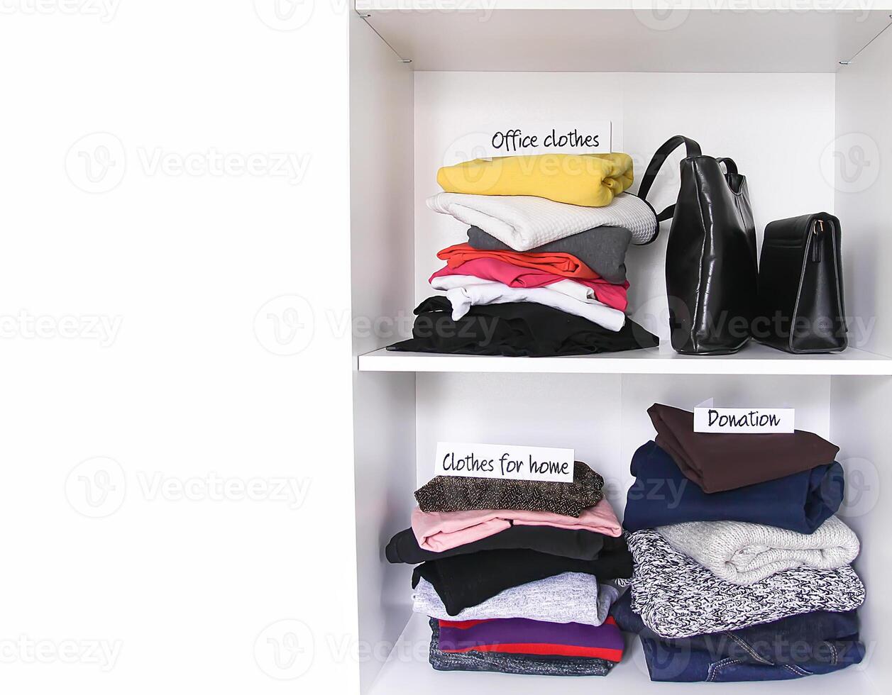 Different clothes in home wardrobe with paper notes. photo