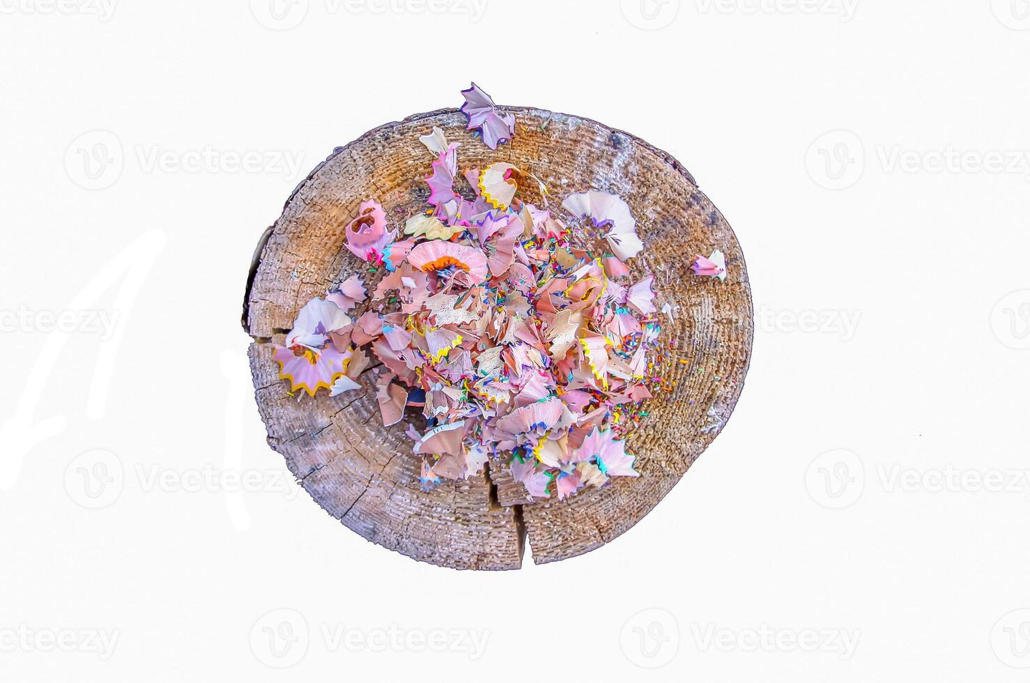 Wooden pencil shavings and colorful crumbs of graphite from sharpener on tree stump. Top view photo