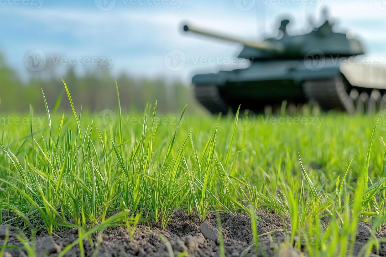 Closeup of spring grass growing in soil with military tank in background photo