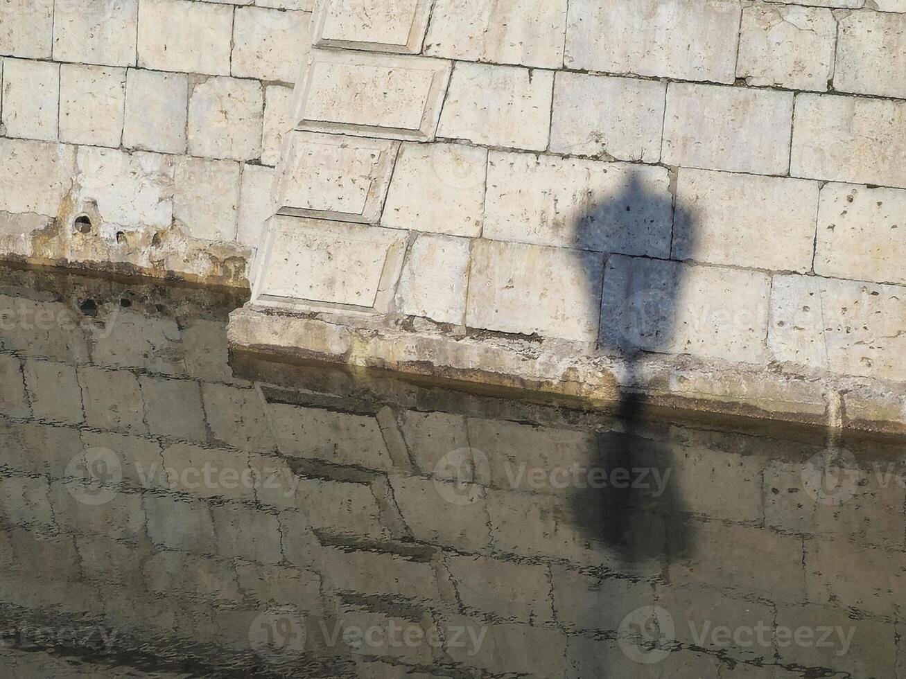 shadow of a city lamp on the fortress wall photo