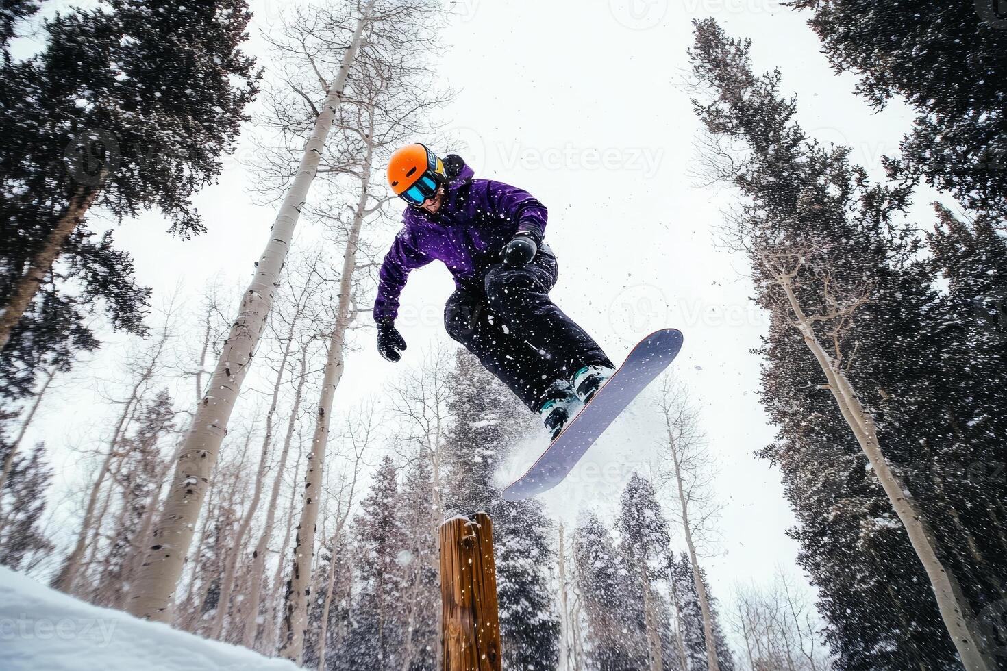Snowboarder executes thrilling backflip over wooden fence in snowy landscape photo