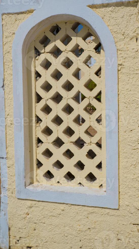 Traditional Arabian architecture, muslim style wooden door and red clay wall photo