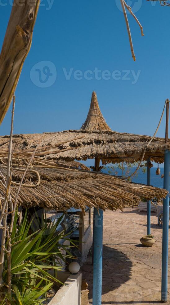 Traditional straw beach umbrella on the beach, with a sunny day on the Mediterranean coast photo