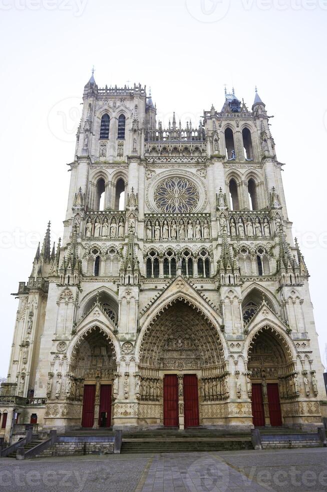 Amiens Cathedral front view with Gothic details and red doors photo