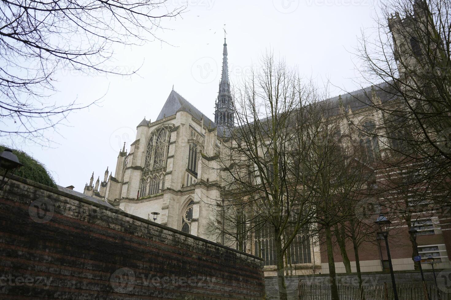 Gothic cathedral spire and stone wall in Amiens, France photo