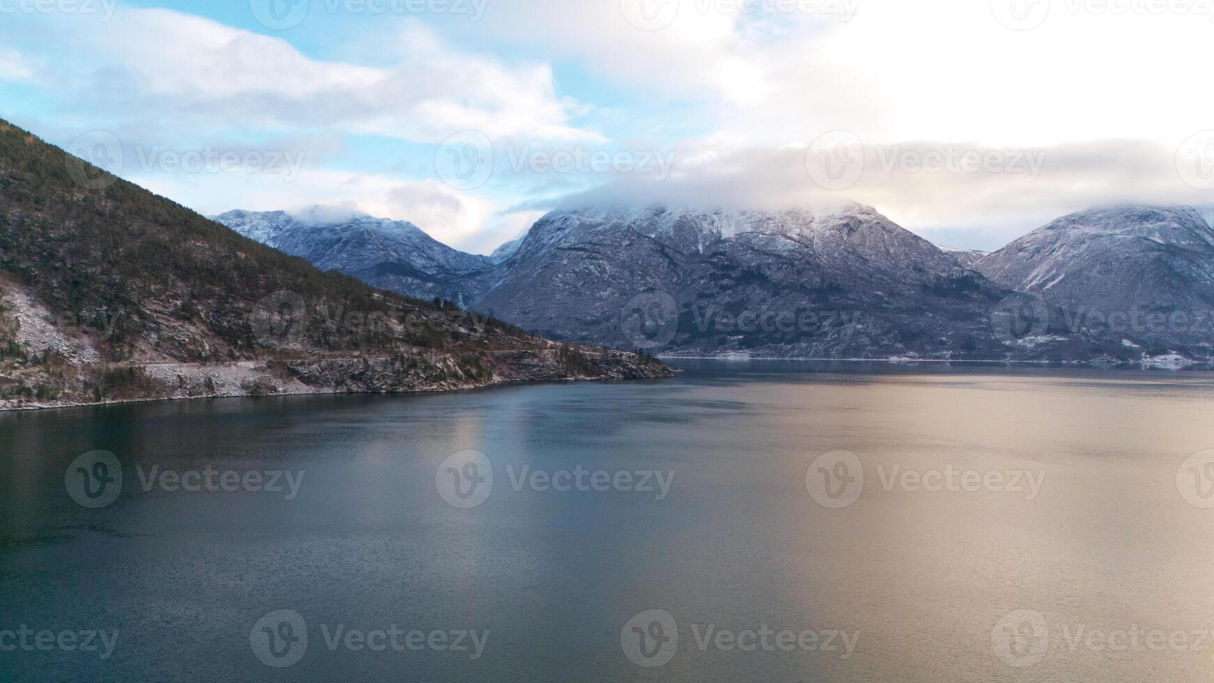 Winter Fjord View in Gaupne, Norway with Snowy Mountains and Cloudy Sky photo