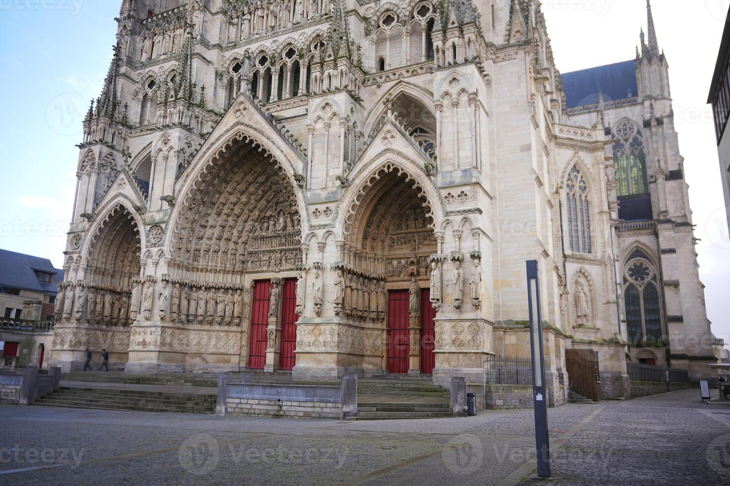 Facade of Gothic cathedral with red doors. Amiens. France 17.02.2025 photo