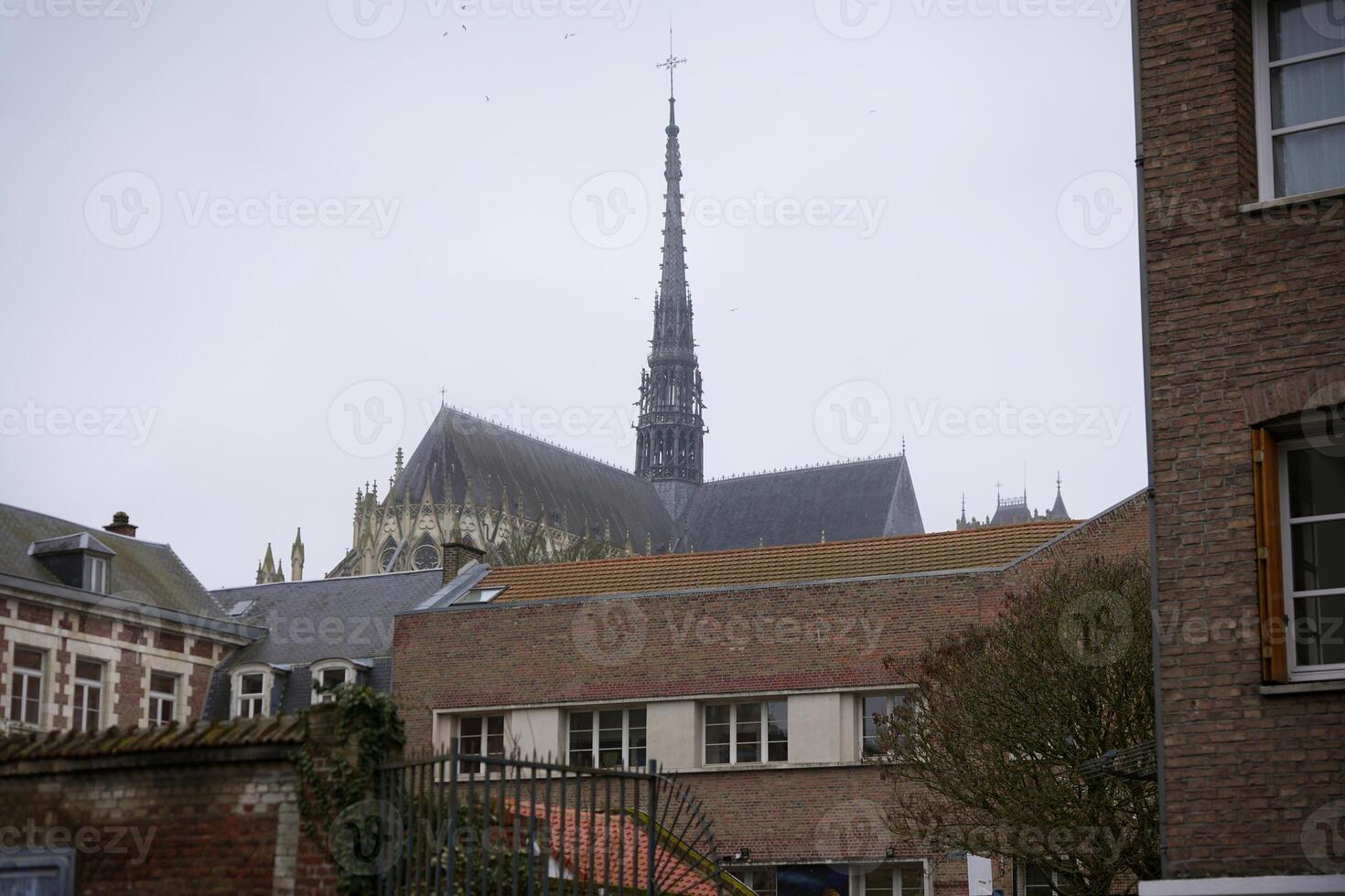 Amiens Cathedral Spire Behind City Buildings photo